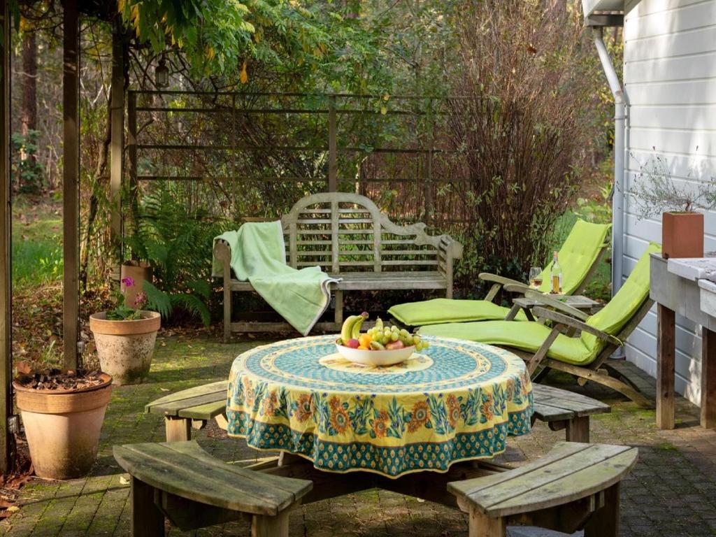 a table with a bowl of fruit on it on a patio at Tranquil bungalow in Lille with garden in Lille