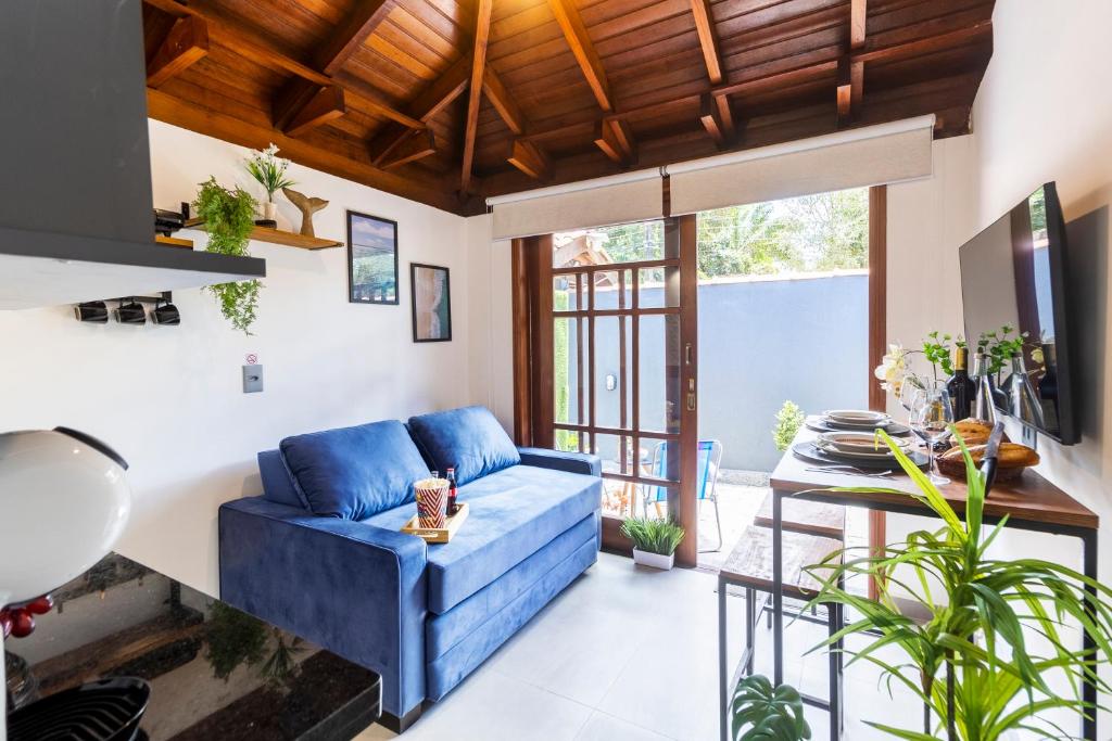 a living room with a blue couch and some plants at Flats Una's Corner - Novos - Ar Condicionado in Barra do Una