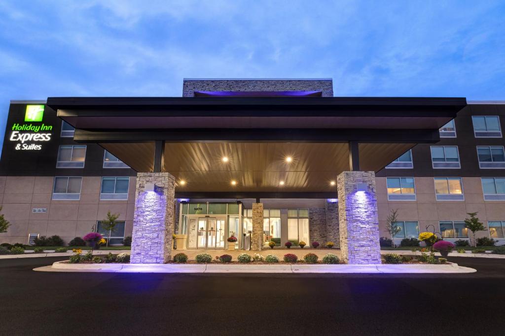 a hotel building with a large lobby with lights at Holiday Inn Express & Suites - Grand Rapids South - Wyoming, an IHG Hotel in Wyoming