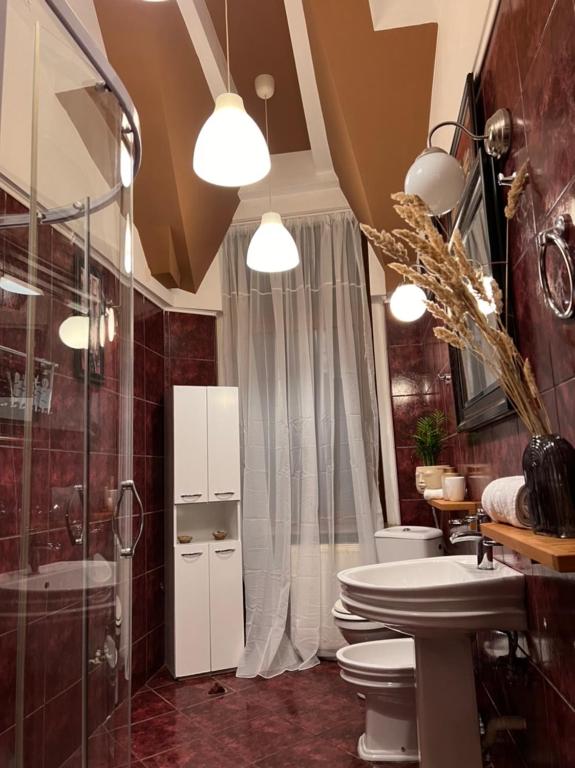 a bathroom with two toilets and a glass shower at Artist Apartment in Braşov