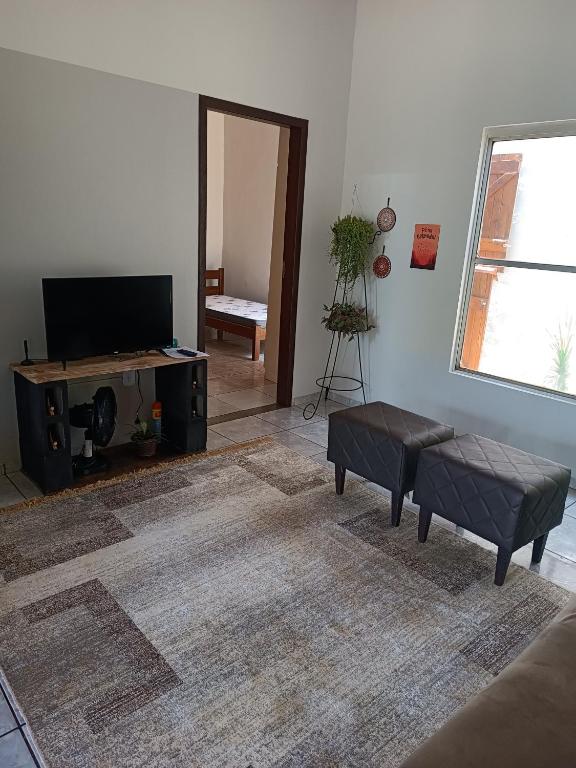 a living room with a flat screen tv and a couch at Casa Ana in Dourados