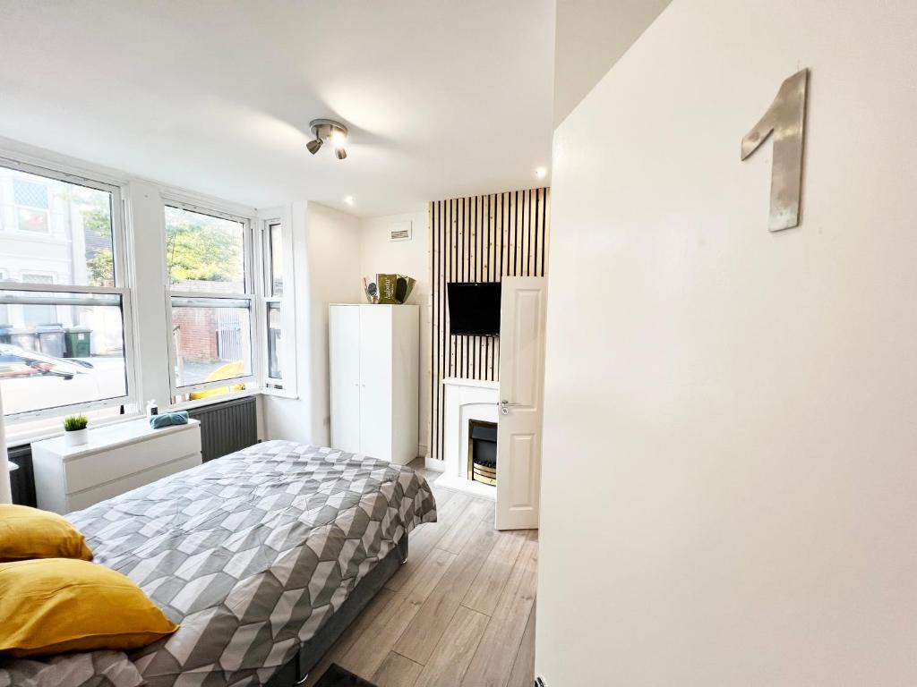 ロンドンにあるMinet Gardens - Centrally located Apartment - Rm 1の白いベッドルーム(ベッド1台、冷蔵庫付)
