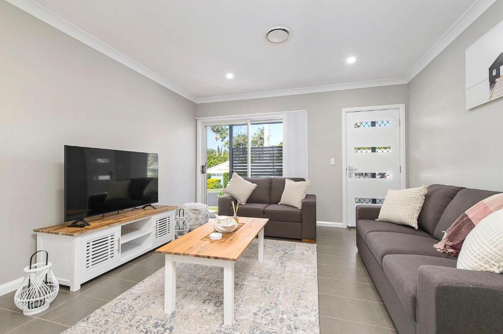 a living room with a couch and a tv at Cathie 29 in Port Macquarie