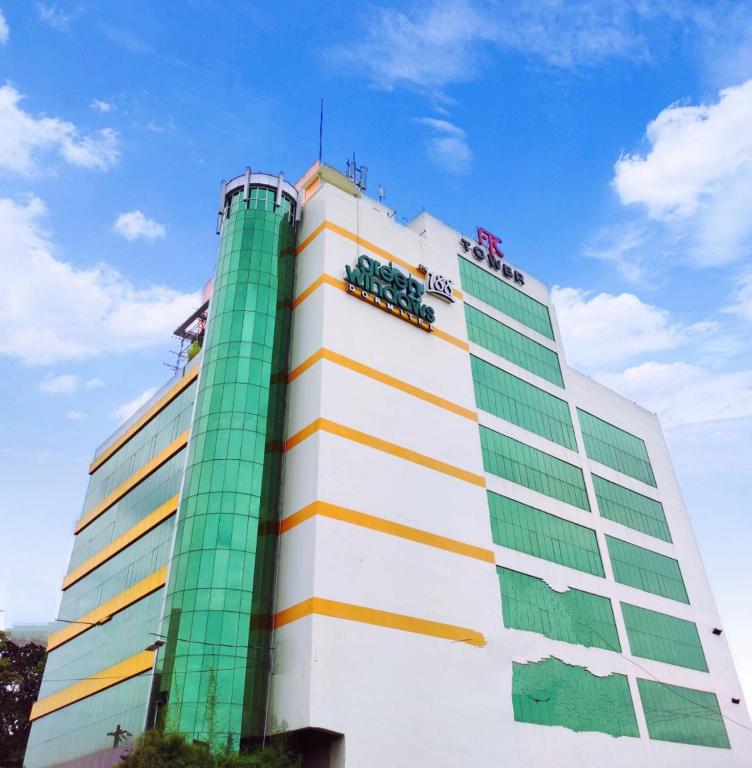 a tall building with green and white at Greenwindows Hotel in Davao City