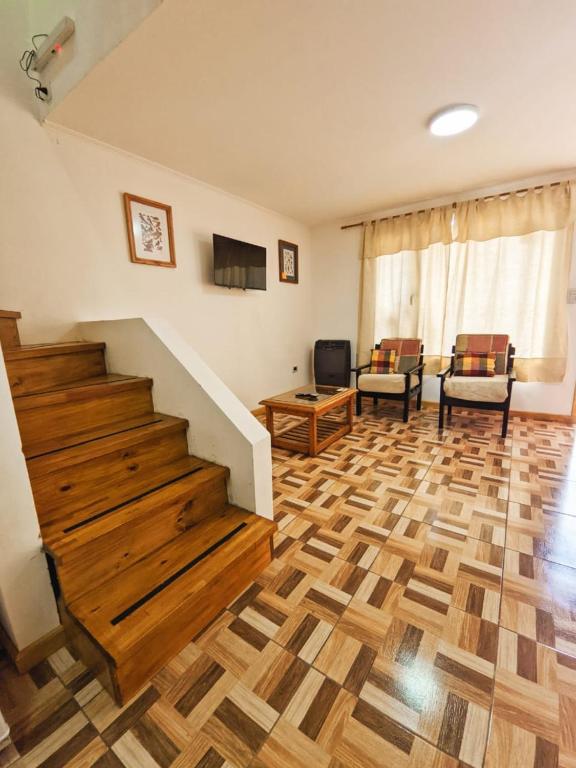 sala de estar con suelo de madera y escaleras en Departamentos Copos de Nieve en El Bolsón