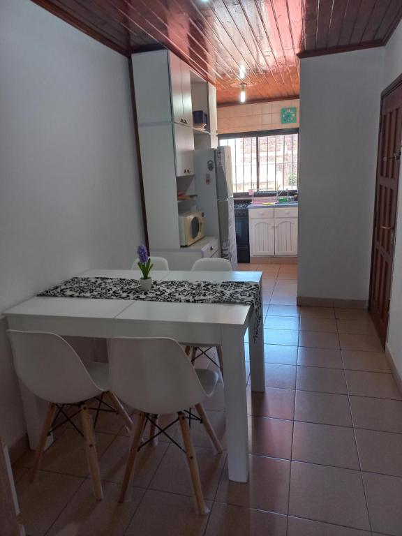 a kitchen with a white table and some chairs at Departamento Céntrico in Posadas