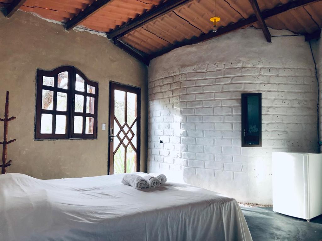 a bedroom with a bed with towels on it at Shanti - Hospedaria na Vila de São Jorge in Sao Jorge
