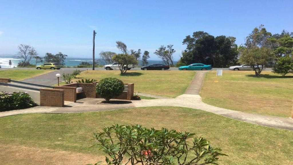 ein Park mit Bänken und Autos auf einer Straße in der Unterkunft Flynns View 8 in Port Macquarie