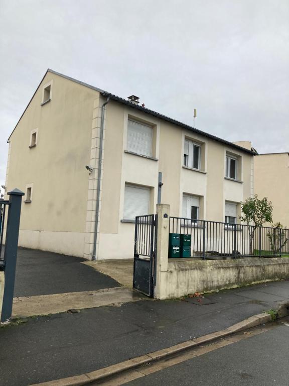 une maison blanche avec un portail et une clôture dans l'établissement Superbe appartement parking gratuit 2, à Aulnay-sous-Bois