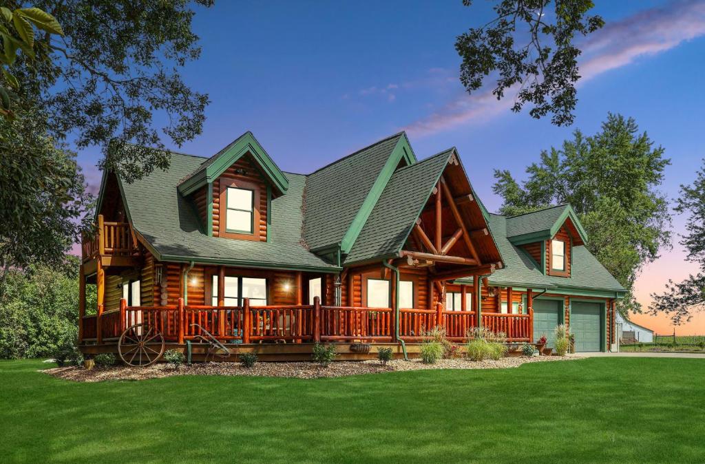 a large log cabin with a large deck at Rustic Cabin with seasonal Pool & Fire Pit - close to to Bike Path in Celina