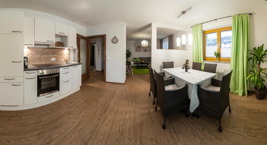 uma cozinha e sala de estar com mesa e cadeiras em Appartements Haidl em Sankt Johann im Pongau