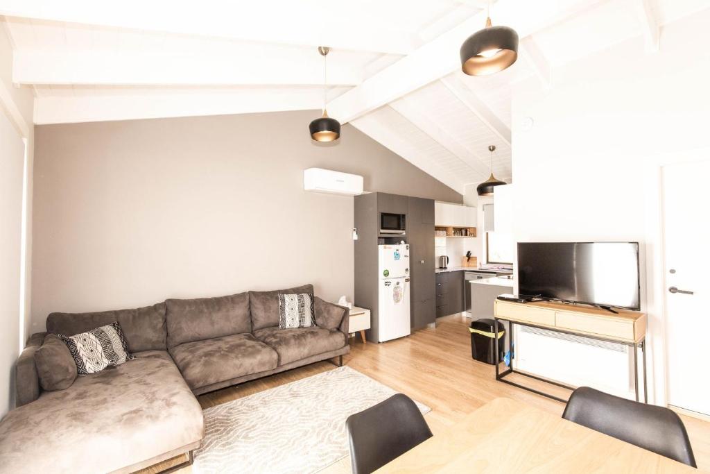 ein Wohnzimmer mit einem Sofa und einem TV in der Unterkunft Eliza Lee 2 50 Gippsland Street in Jindabyne