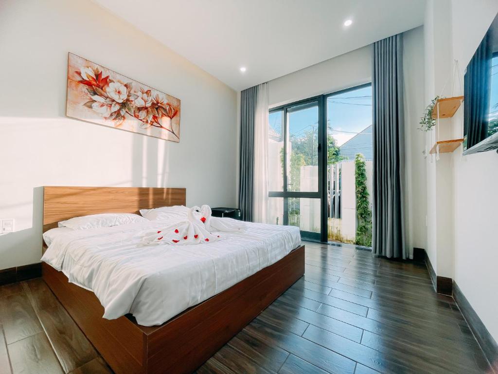 a bedroom with a large bed and a large window at Mia Homestay in Hoi An