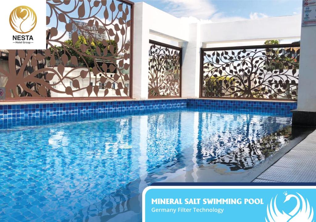 a swimming pool in a villa with a mural of akritkritkrit swimming at Nesta Hotel Saigon in Ho Chi Minh City