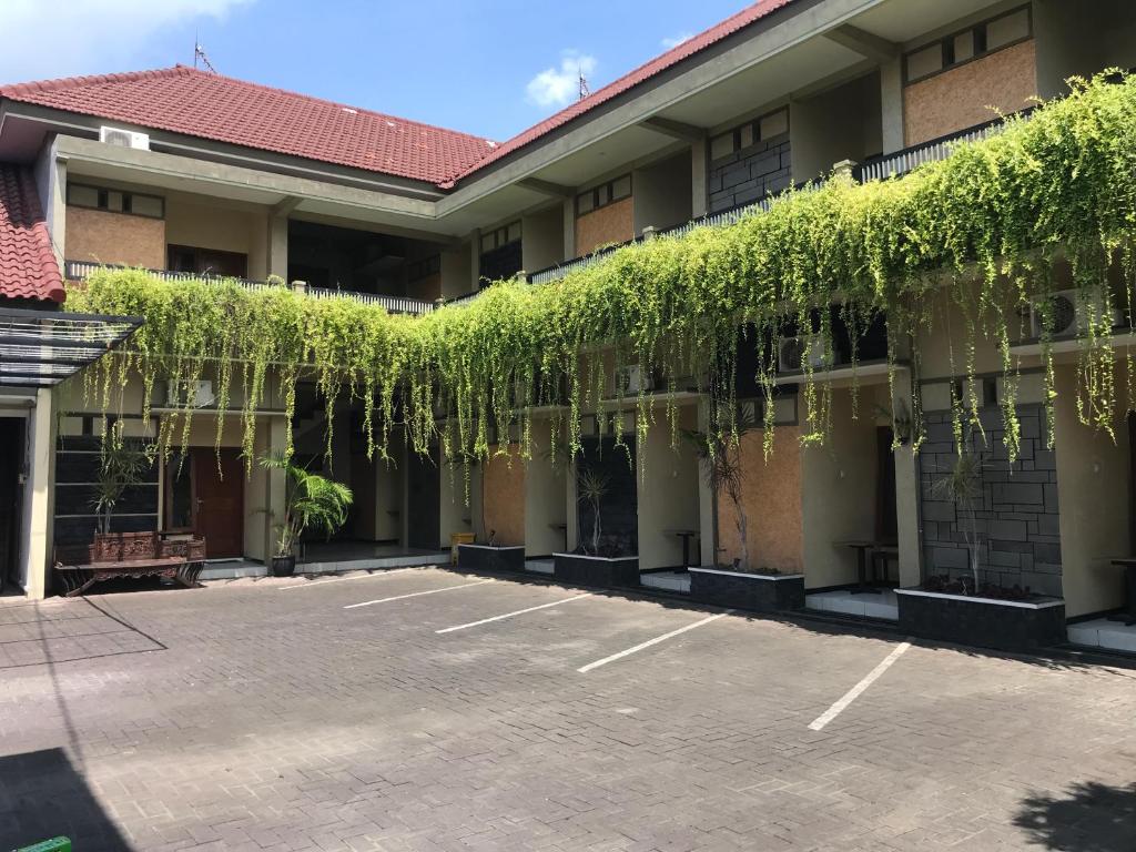 a parking lot in front of a building with vines at Harys homestay in Triwung