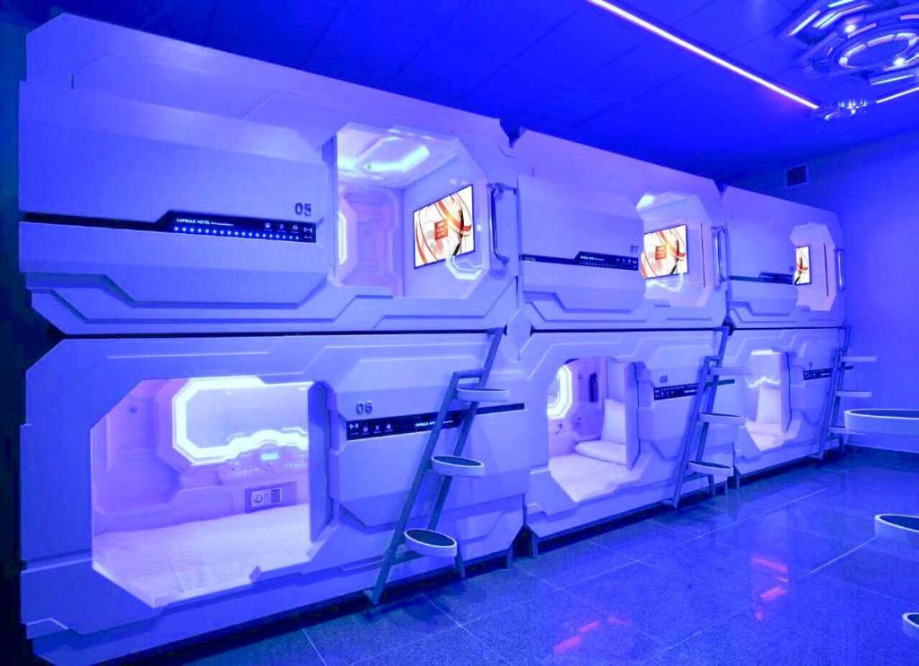 a room with three bunk beds in an airplane at Bestow Capsule Hostel in Kuala Lumpur