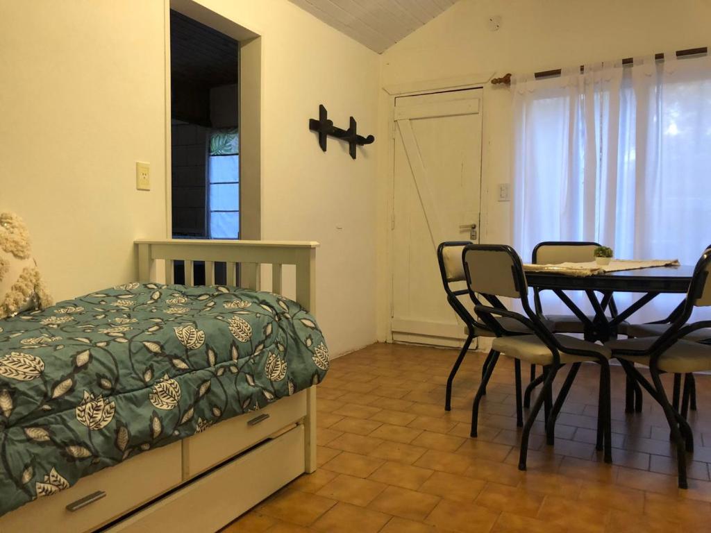 1 dormitorio con 1 cama, mesa y sillas en LasMagnolias en San Carlos de Bariloche