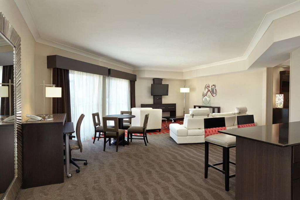 a hotel room with a living room and a dining room at Holiday Inn Express & Suites Naples Downtown - 5th Avenue, an IHG Hotel in Naples