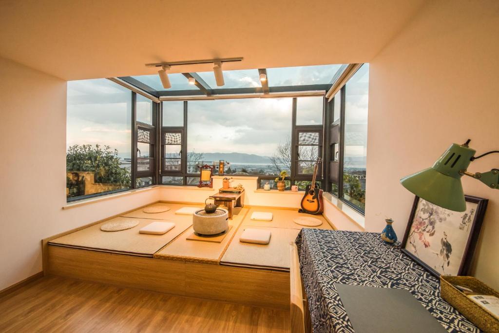 ein Zimmer mit einem großen Fenster mit einem Bett davor in der Unterkunft Dali Dream House with Seaview in Dali