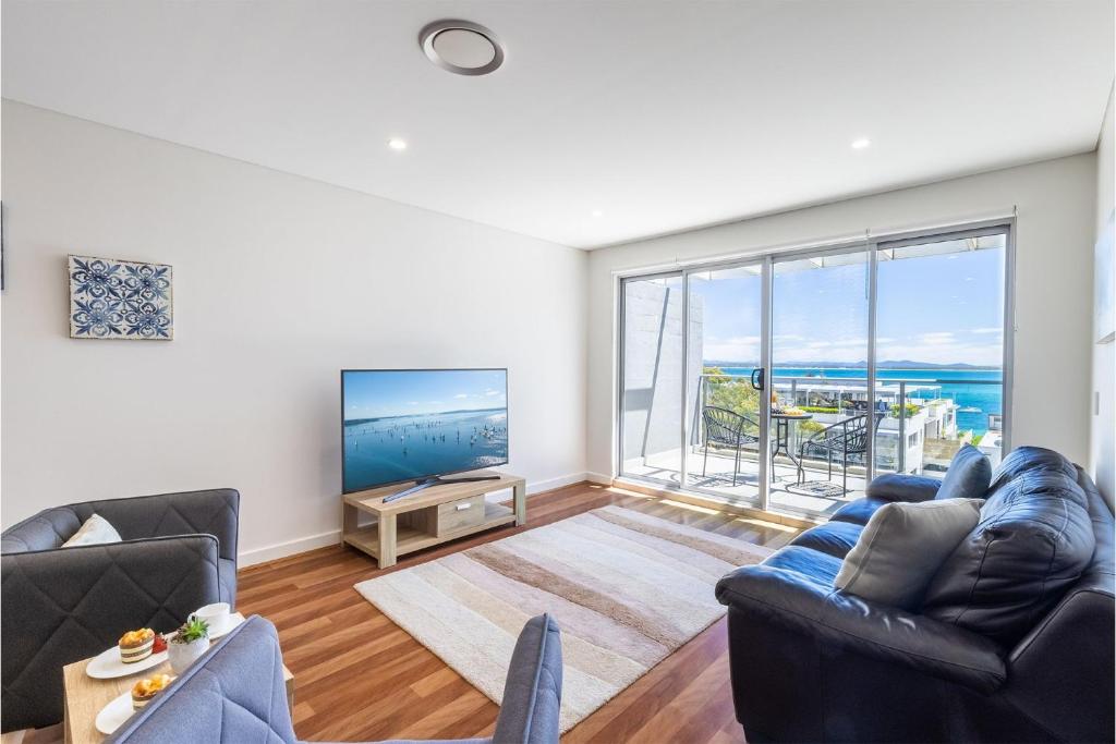 a living room with a couch and a tv at The Shoal 503 Avra Seabreeze in Shoal Bay