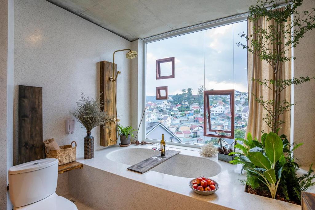 a bathroom with a sink and a large window at Cherry Suites Dalat in Da Lat