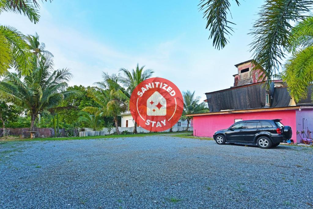 um carro estacionado em frente a um edifício cor-de-rosa em OYO 90689 Chalet Kak Siti em Kuala Terengganu