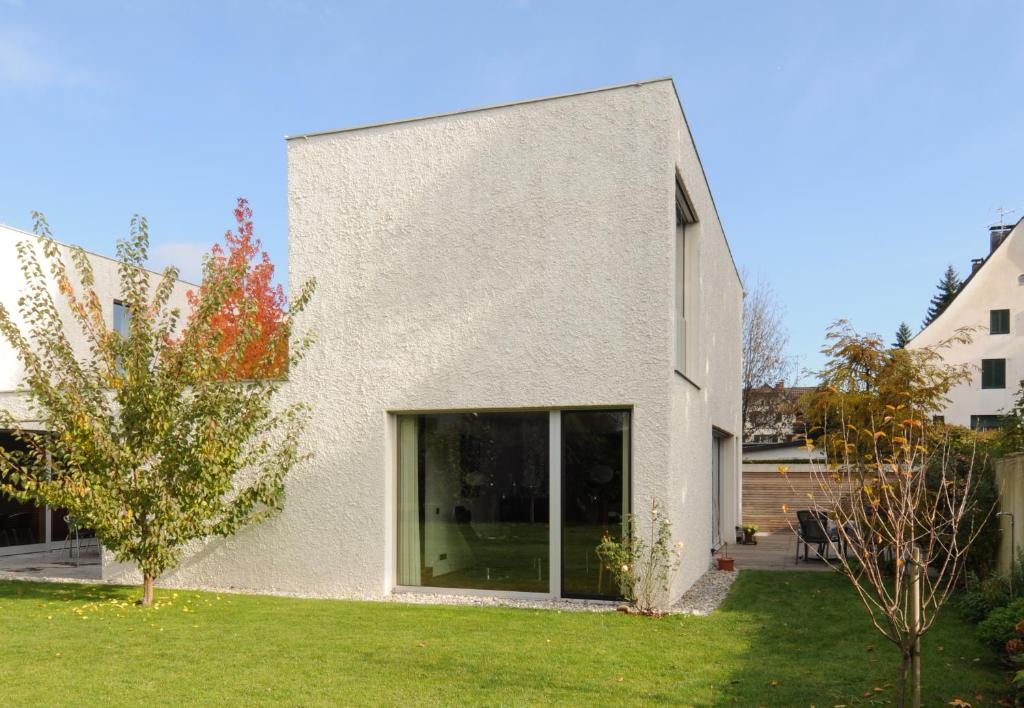 a white house with a large window in a yard at Ferienhaus S11 Lustenau in Lustenau