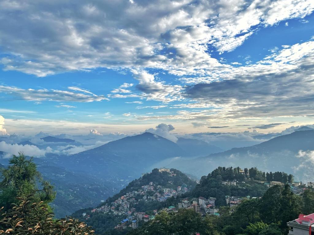 una vista de una ciudad en las montañas bajo un cielo nublado en The Di-Lac Retreat en Gangtok