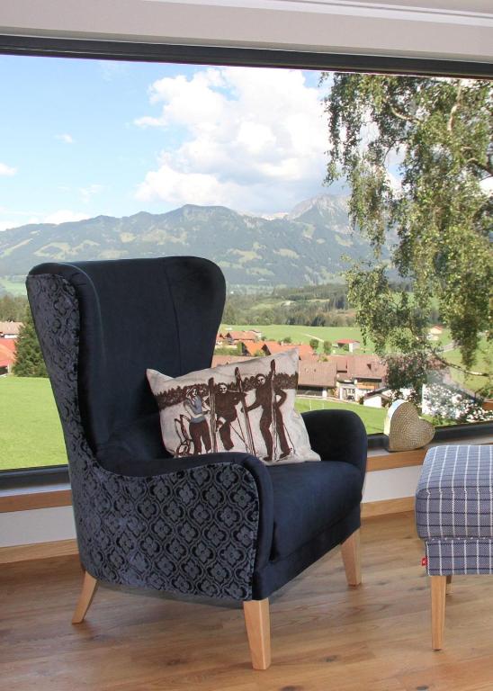 a chair in a room with a large window at Bergzauber Alpin Suites - Skipiste - Private Sauna in Bolsterlang