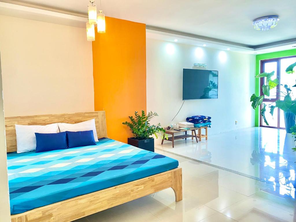 um quarto com uma cama com paredes azuis e laranja em Homestay Vung Tau - zozo 173 em Vung Tau