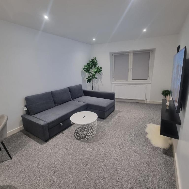 sala de estar con sofá azul y mesa en 2 bed apartment in Plumstead London, en Plumstead