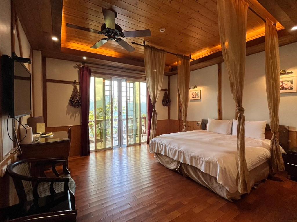 a bedroom with a bed and a ceiling fan at Cingjing Vienna Pleasance Cottage in Ren&#39;ai