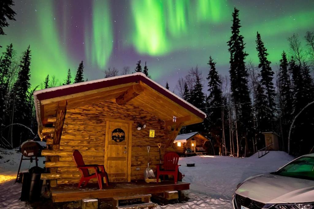 domek z krzesłami i aurora na niebie w obiekcie 1 Bd Deluxe Log Cabin View Northern Lights w mieście Fairbanks