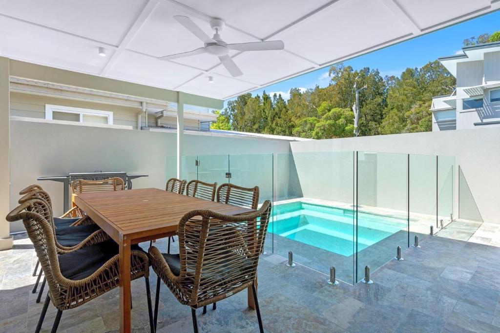 a dining room with a table and chairs and a swimming pool at Ilanga Jervis Bay-Heated Pool in Huskisson