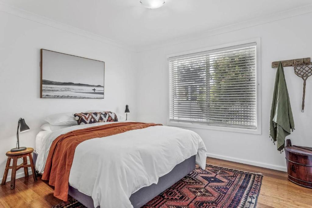 a white bedroom with a bed and a window at Swell Jervis Bay in Vincentia