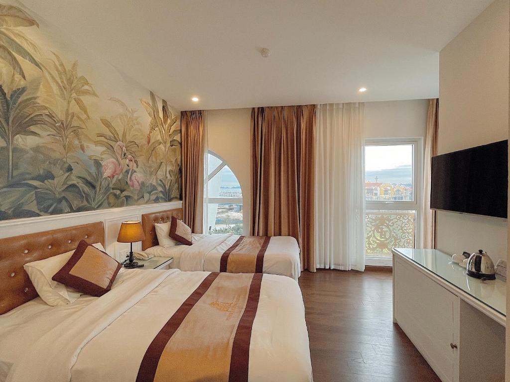 um quarto de hotel com duas camas e uma grande janela em Pusan Halong Hotel em Ha Long