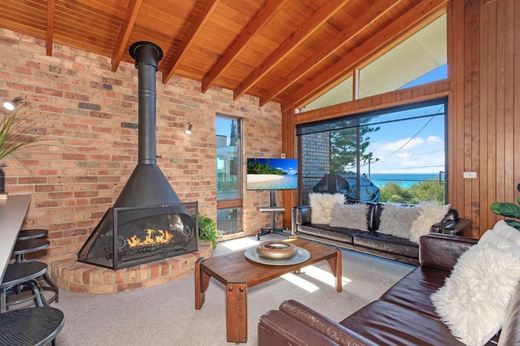 a living room with a brick wall and a fireplace at Beachcombers on Collingwood Beach in Vincentia