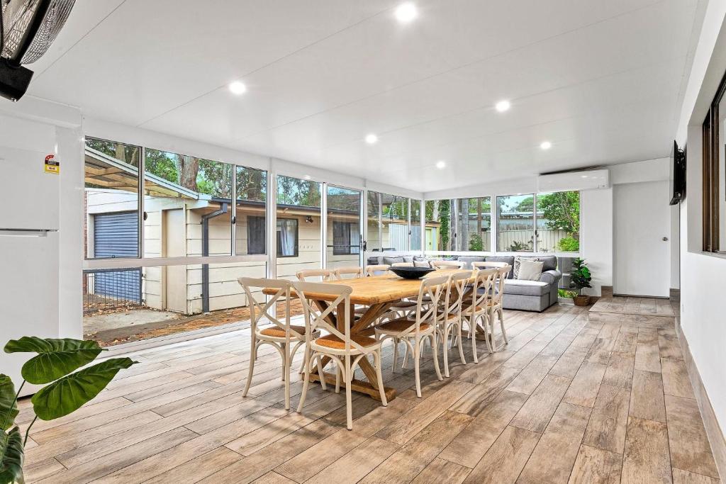 ビンセンチアにあるFamily Tides Beach Escapeのオープンリビングルーム(木製テーブル、椅子付)