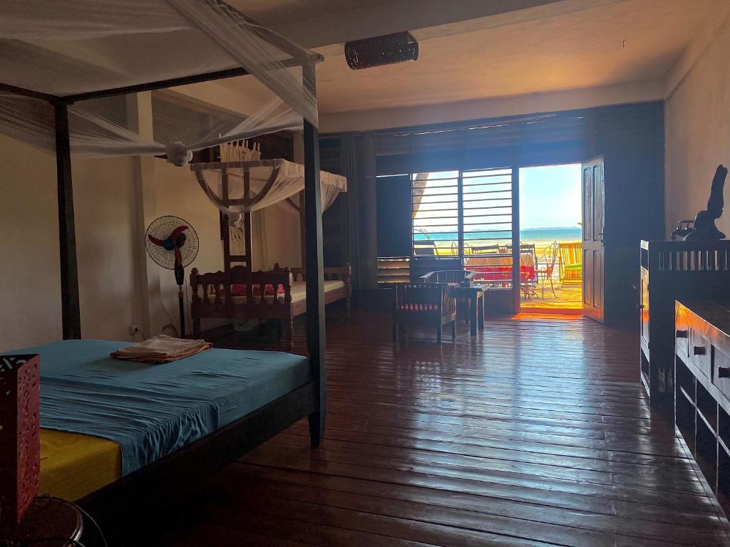 1 dormitorio con 1 cama y 1 habitación con balcón en villa Mena, en Nosy Be