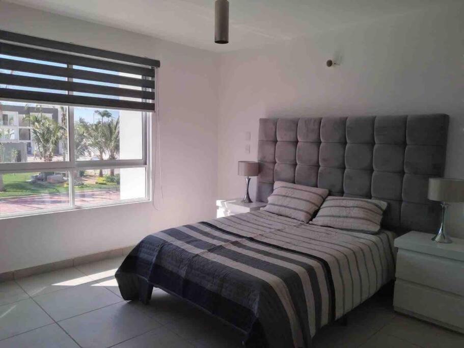 - une chambre avec un grand lit et une grande fenêtre dans l'établissement Hermosa casa en Acapulco con club de Playa., à Acapulco