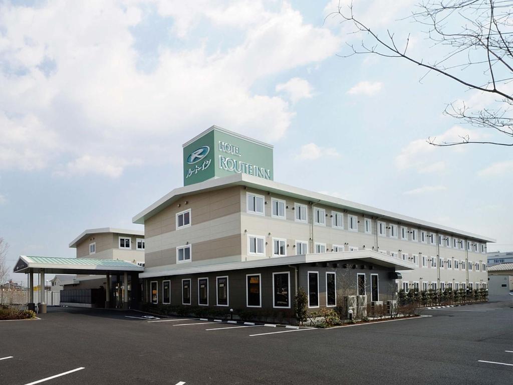 un grande edificio con un cartello sopra di Hotel Route Inn Tagajo-Eki Higashi a Tagajo