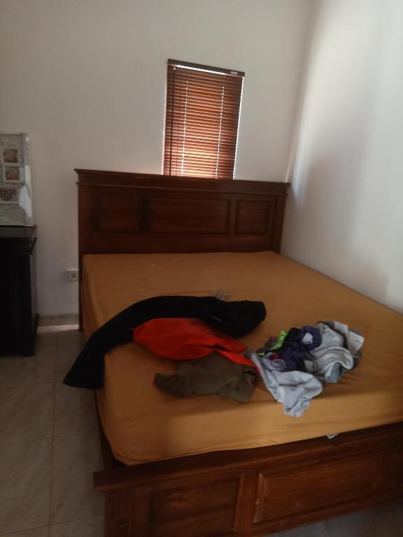 - une chambre avec un lit et des vêtements dans l'établissement D'pondok Batu Jaran, à Kubu
