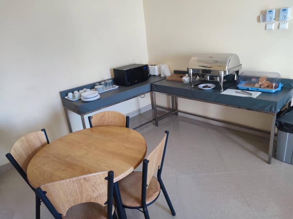 a table and chairs in a room with a kitchen at Djibguesthouse in Djibouti