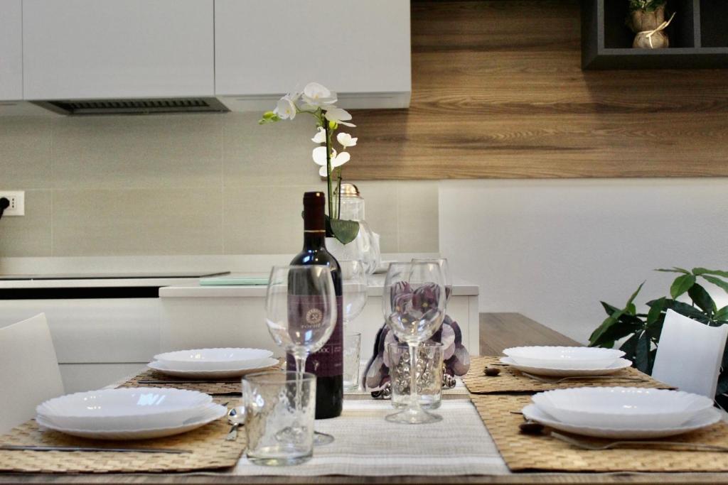una mesa con platos y una botella de vino y copas en Home Viale Trento 16, en Cagliari