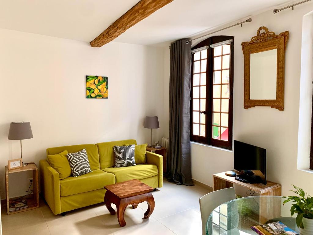 a living room with a yellow couch and a table at La Maison du Courtil, Citron-Caramel in Moustiers-Sainte-Marie