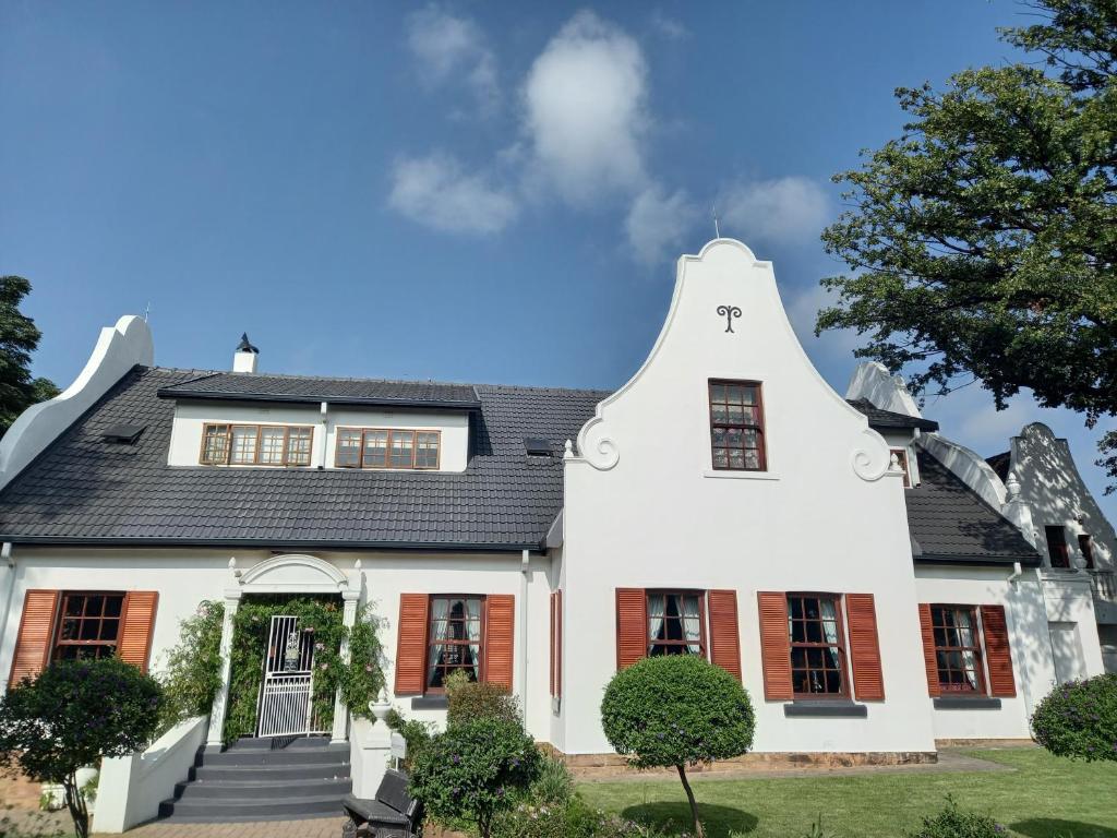 een groot wit huis met een zwart dak bij Oak View Manor in Heidelberg