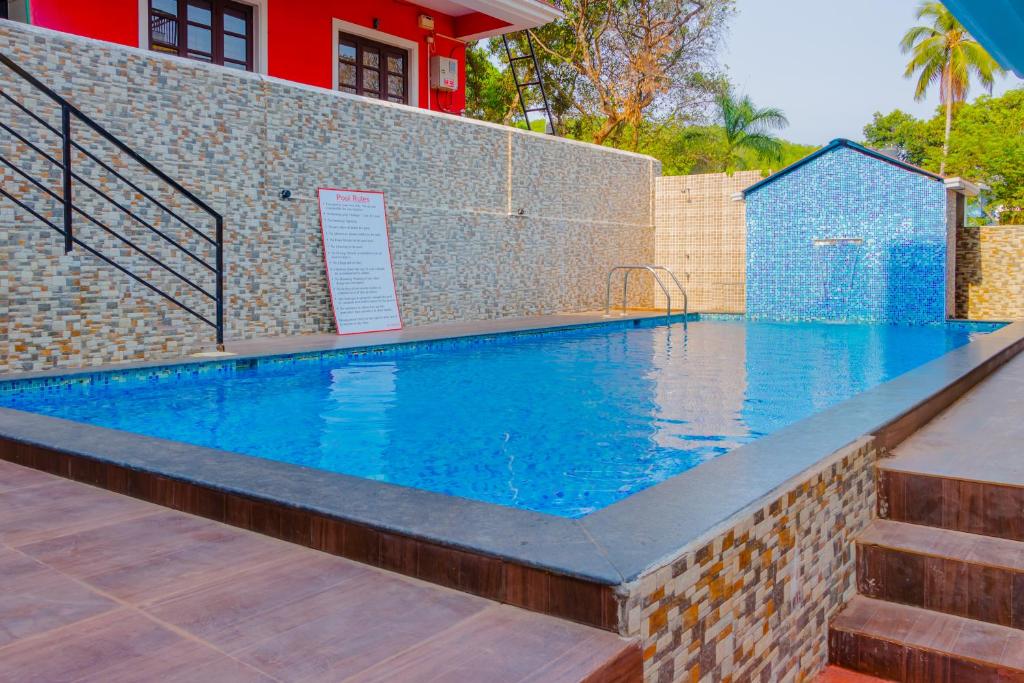 una gran piscina con pared de ladrillo y aicrobialicrobialicrobial en Spacious 3 bhk new stylish villa in Vagator en Vagator