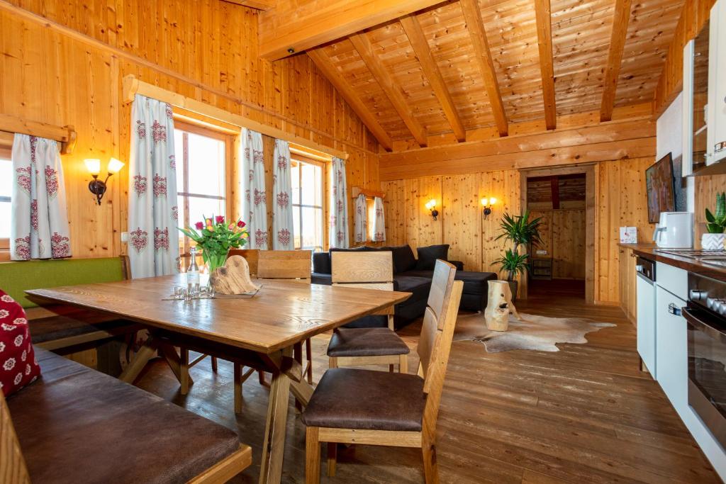 uma sala de jantar e sala de estar num chalé de madeira em Apartment Grammlergut em Maria Alm am Steinernen Meer
