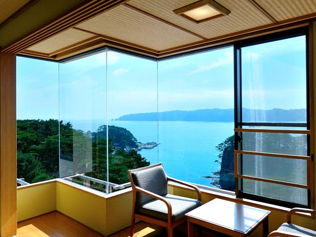 a room with a large window with a view of the water at Jodogahama Park Hotel in Miyako