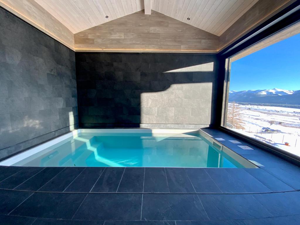 a swimming pool in a house with a window at Artik chalet avec vue à 180 degrés et piscine in Les Angles